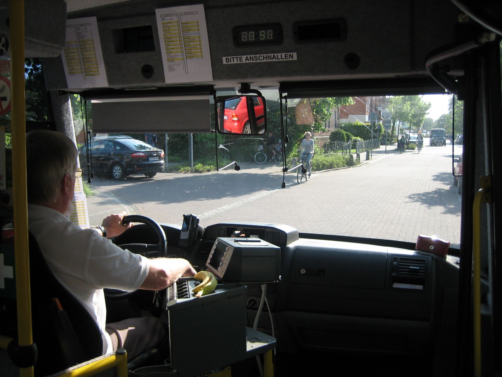 Blick aus Frontscheibe eines Busses, Busfahrer am Lenkrad