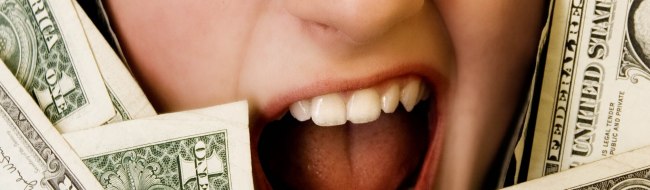 Gesicht einer jungen Frau, die zwischen Geldscheinen hindurchschaut