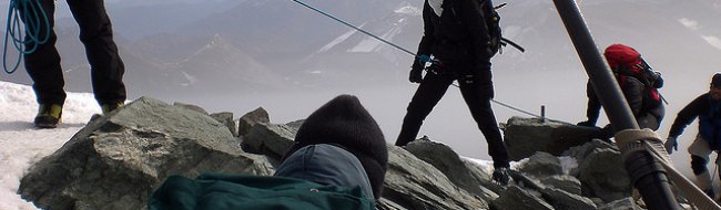 Bergsteigergruppe, die angeleint über Felsen steigen
