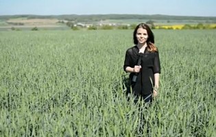 Junge Frau mit Mikrofon in Weizenfeld