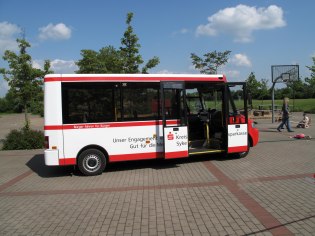 Bürgerbus von Weyhe mit geöffneter Tür auf gepflastertem Platz 