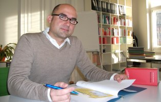 Foto: Katharina Fiedler Jan Heckmann an Schreibtisch, blättert in Akte