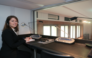 Kristina Borger in einer Simultankabine mit großem Fenster.