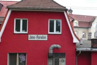 Rotes Bahnhofshäuschen mit Schild "Jena-Paradies"