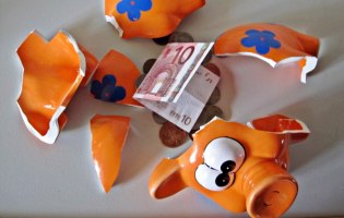 kaputtes Sparschwein mit 10-Euro-Schein und Euro-Münzen