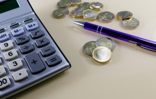 Taschenrechner, Kugelschreiber und Geldmünzen