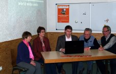 Marco Hess an Tisch mit Laptop, neben ihm vier ältere Männer und Frauen, die ihm zusehen